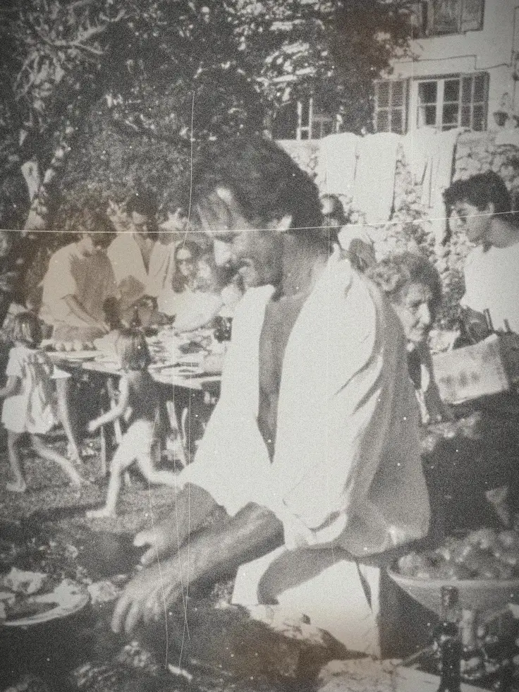 Un homme fait griller la viande lors d'un déjeuner de famille en plein air