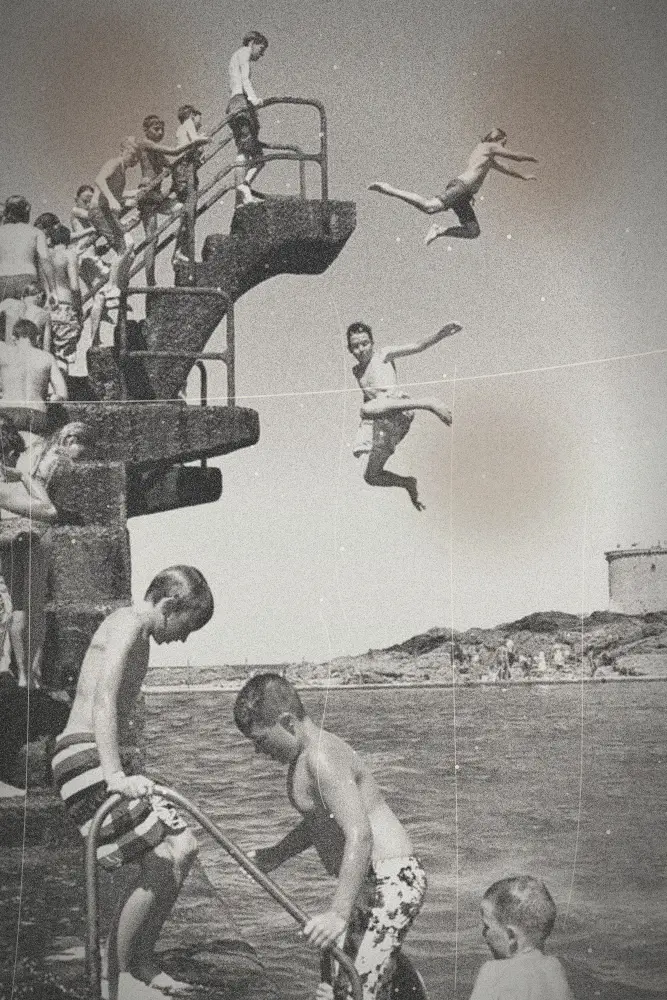 Des enfants sautent d'un plongeoir en pierre dans la mer